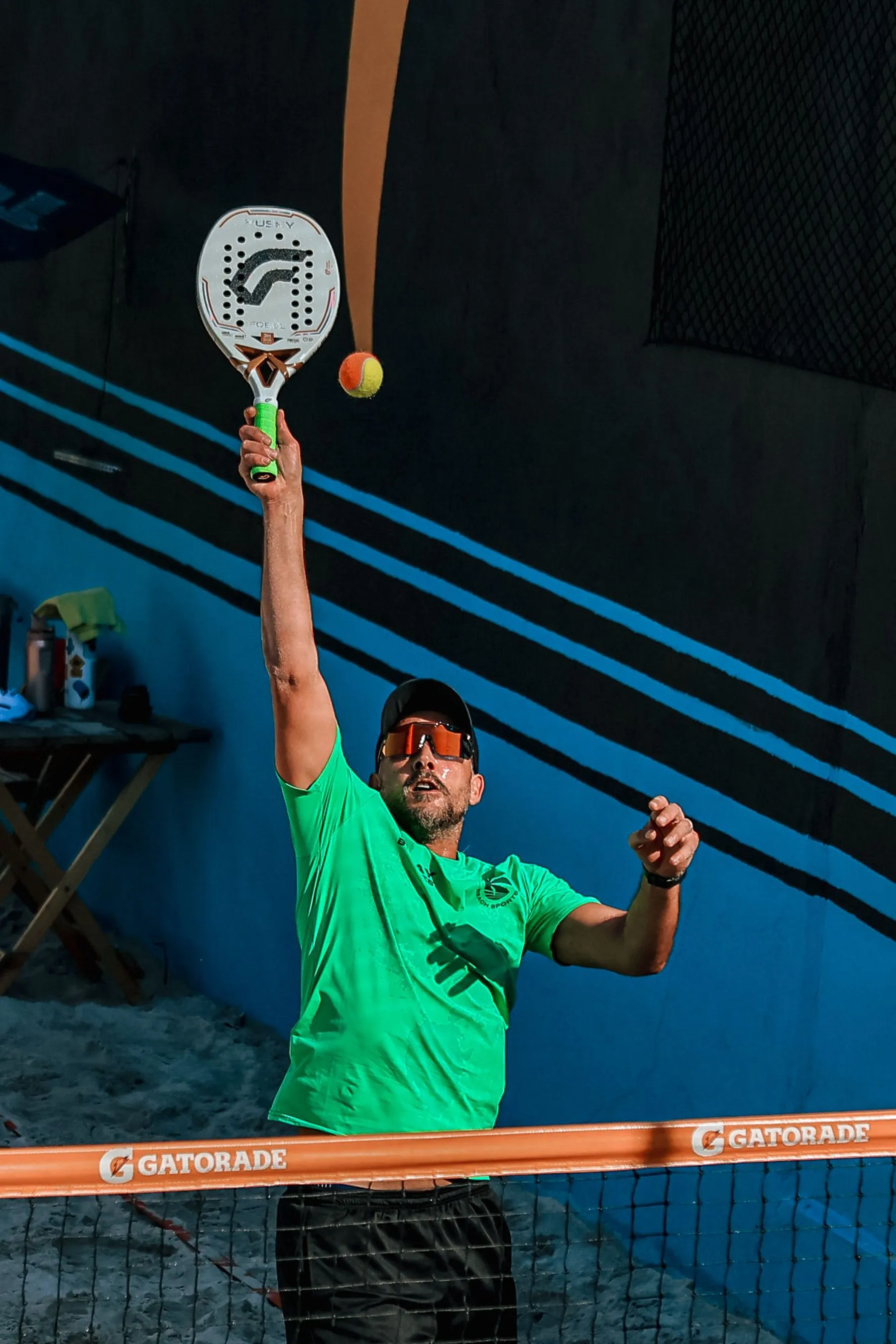 Padelspieler springt auf einem Outdoor-Court zu einem kraftvollen Überkopfschlag